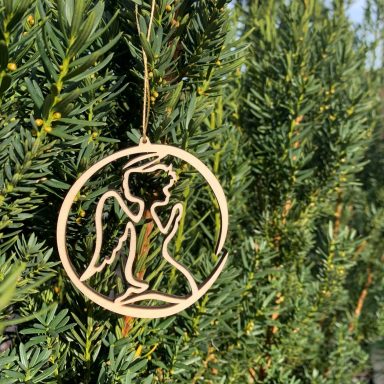 Engelornament in einem Kreis, hing an einem grünen Nadelbaum.